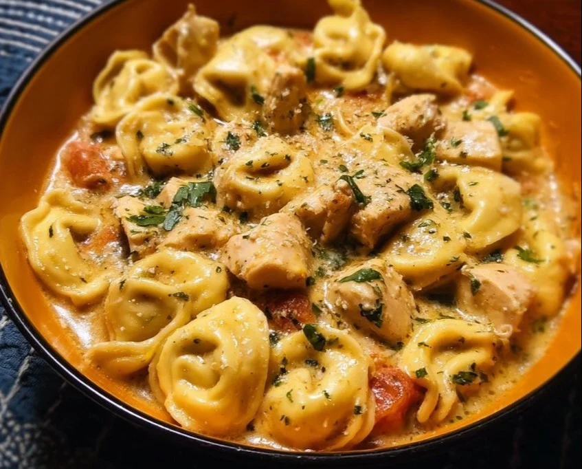 CrockPot Chicken Tortellini served in a bowl with herbs on top
