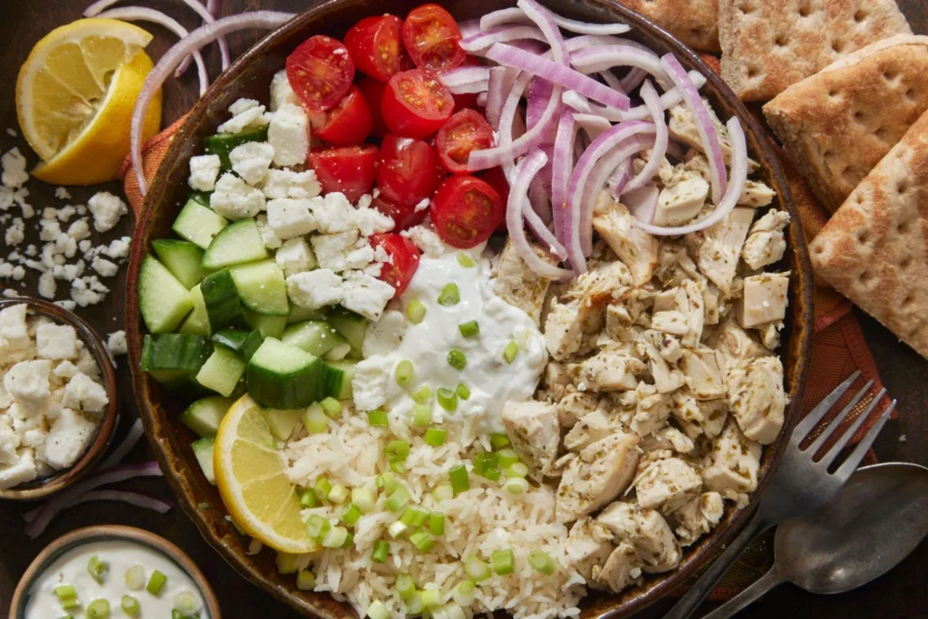Delicious Greek Chicken Bowl topped with fresh vegetables and feta cheese