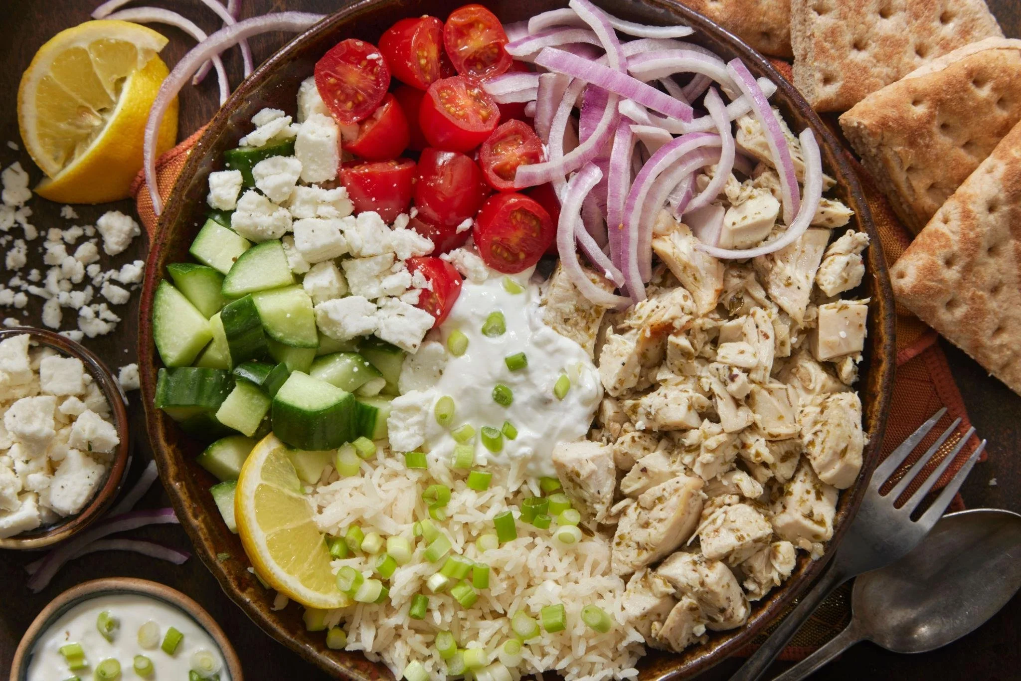 Delicious Greek Chicken Bowl topped with fresh vegetables and feta cheese