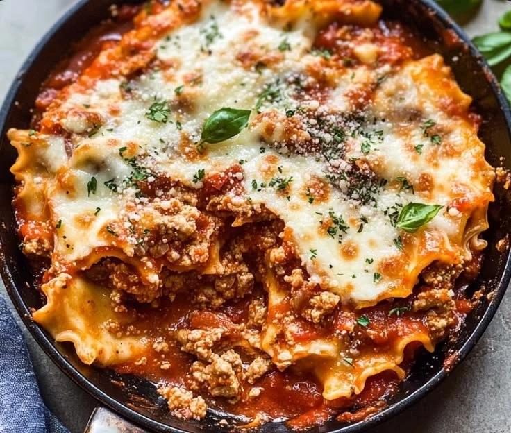 One Pan Skillet Lasagna served in a cast iron skillet with fresh herbs