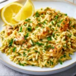 Creamy lemon chicken orzo dish garnished with fresh herbs
