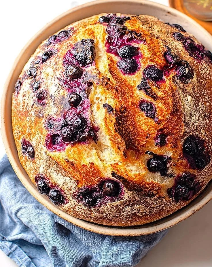 Freshly baked rustic blueberry sourdough bread with berries.