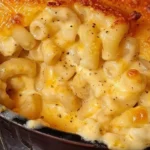 Bowl of classic creamy mac and cheese garnished with herbs